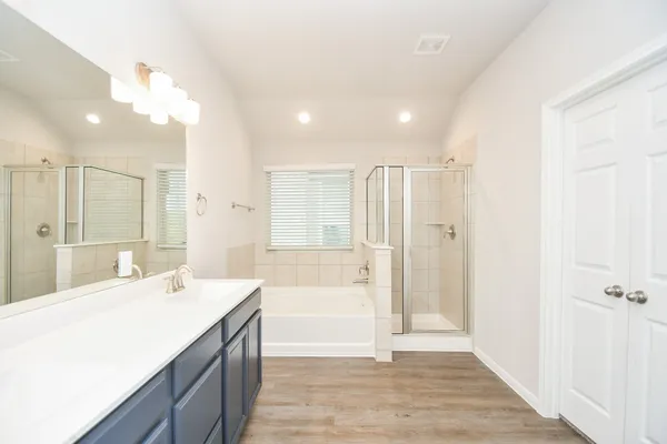 a spacious bathroom with a shower a sink and a mirror