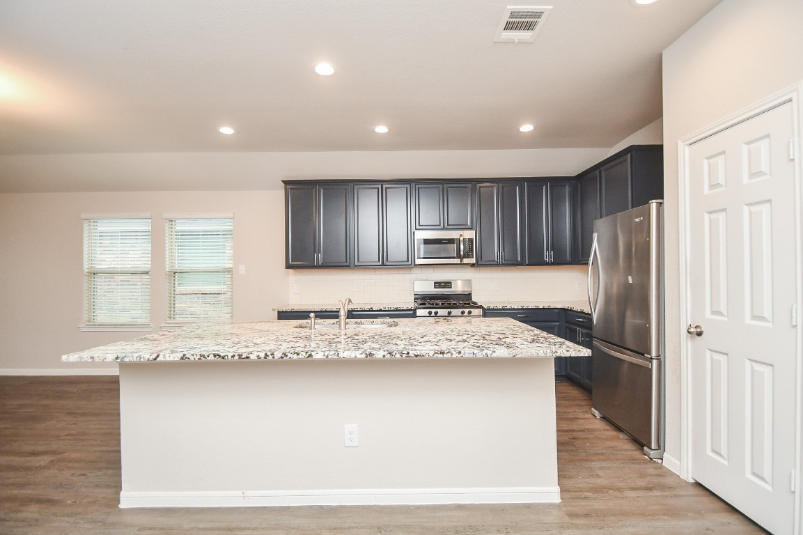 17811 Chartertree Lane Tomball, TX 77377 - Photo 6 of 32 a kitchen with stainless steel appliances granite countertop a sink refrigerator and cabinets