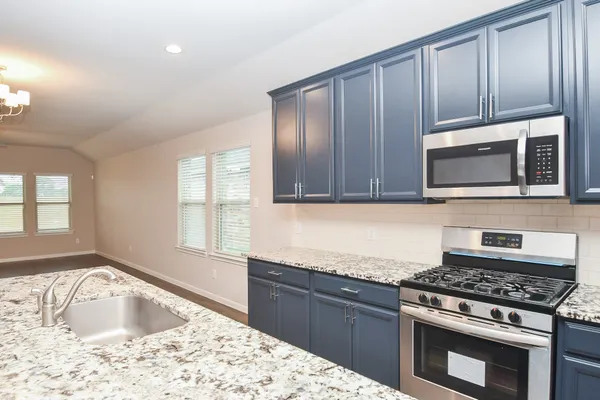 a kitchen with wooden cabinets and a stove top oven