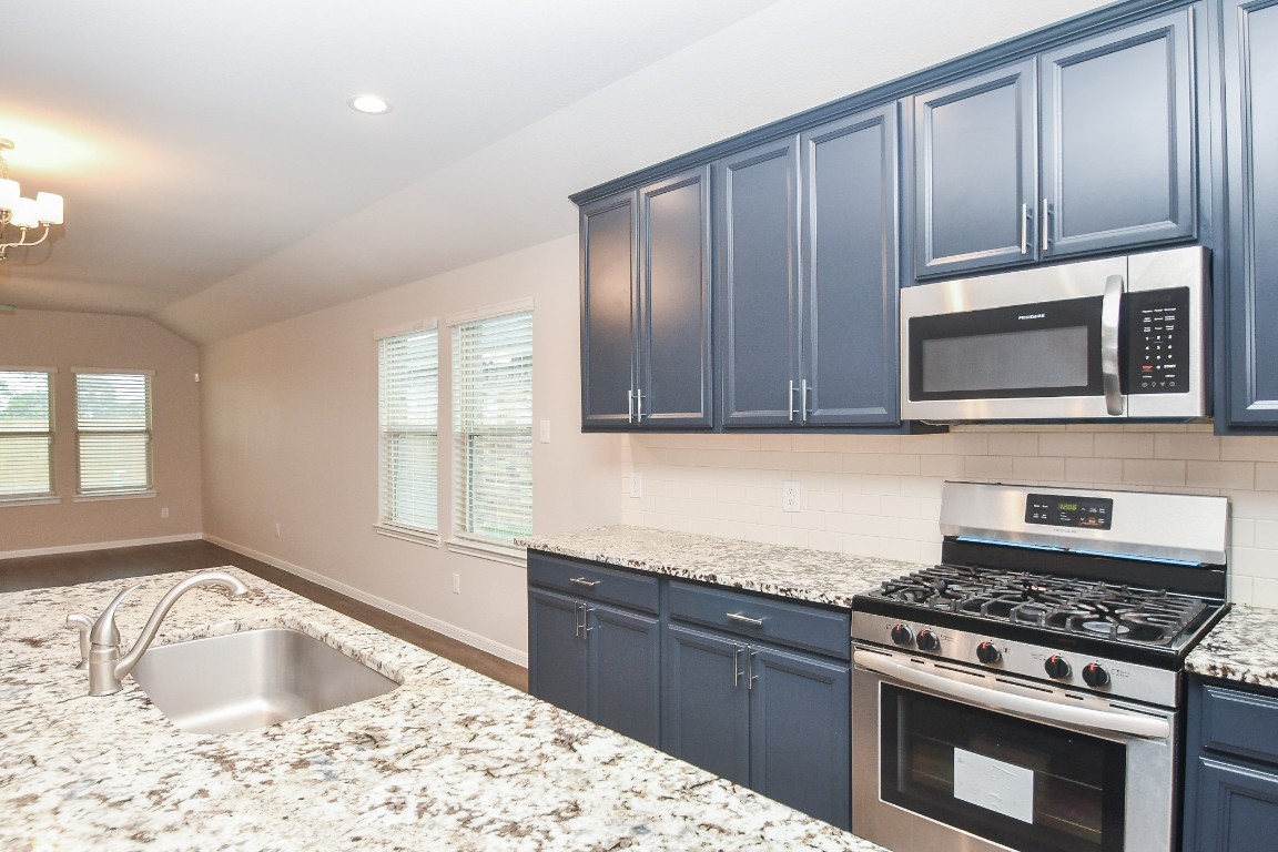 17811 Chartertree Lane Tomball, TX 77377 - Photo 10 of 32 a kitchen with wooden cabinets and a stove top oven