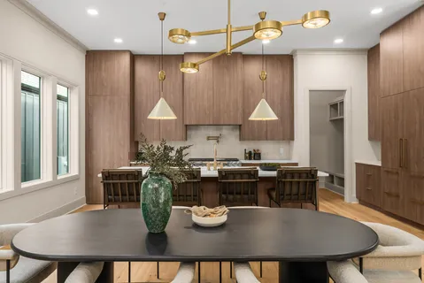 a kitchen with a dining table chairs and stove