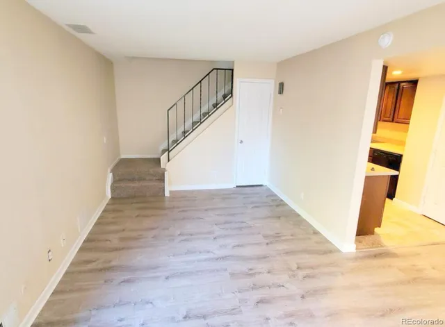 a view of a hallway with wooden floor and entryway