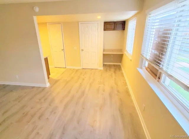 a view of a room with wooden floor and door