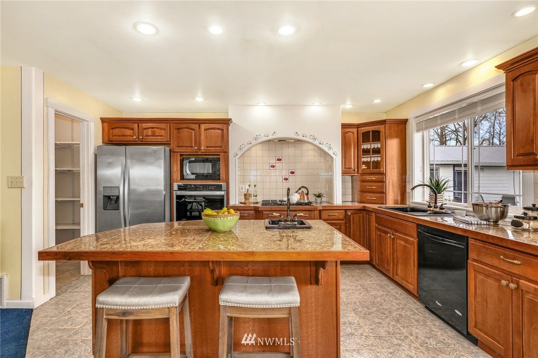 15123 High Bridge Road Monroe, WA 98272 - Photo 8 of 40 a kitchen with stainless steel appliances granite countertop a sink a stove and a refrigerator