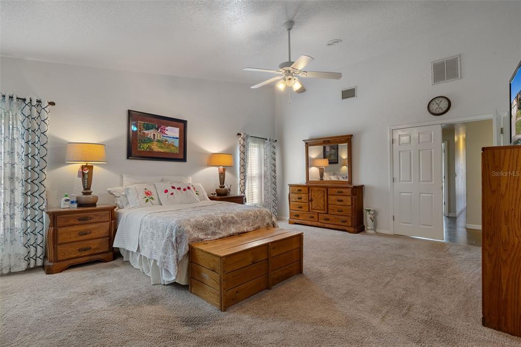 10421 Templewood Court Spring Hill, FL 34608 - Photo 27 of 63 a spacious bedroom with a bed a couch and dresser