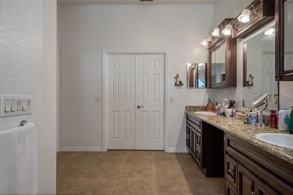 10421 Templewood Court Spring Hill, FL 34608 - Photo 31 of 63 a spacious bathroom with a granite countertop sink a large mirror and a