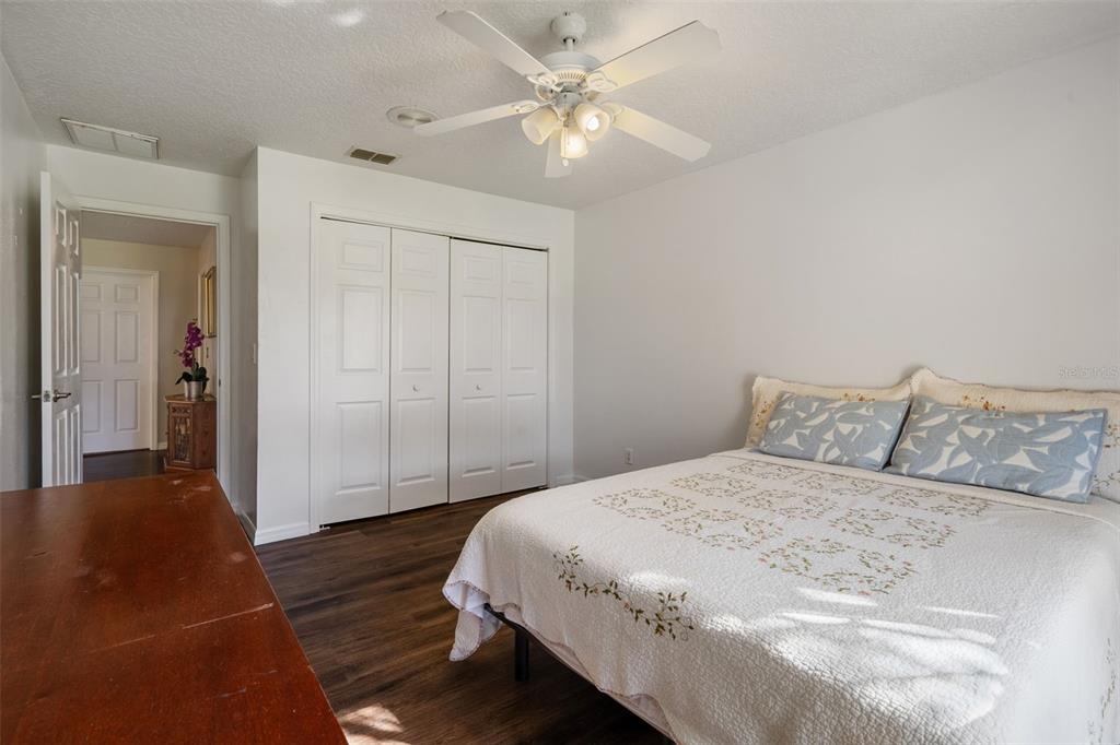 10421 Templewood Court Spring Hill, FL 34608 - Photo 37 of 63 a spacious bedroom with a bed and a chandelier