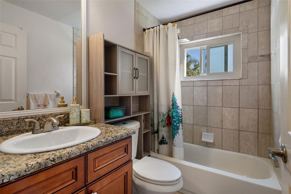 10421 Templewood Court Spring Hill, FL 34608 - Photo 38 of 63 a bathroom with a granite countertop sink toilet and shower