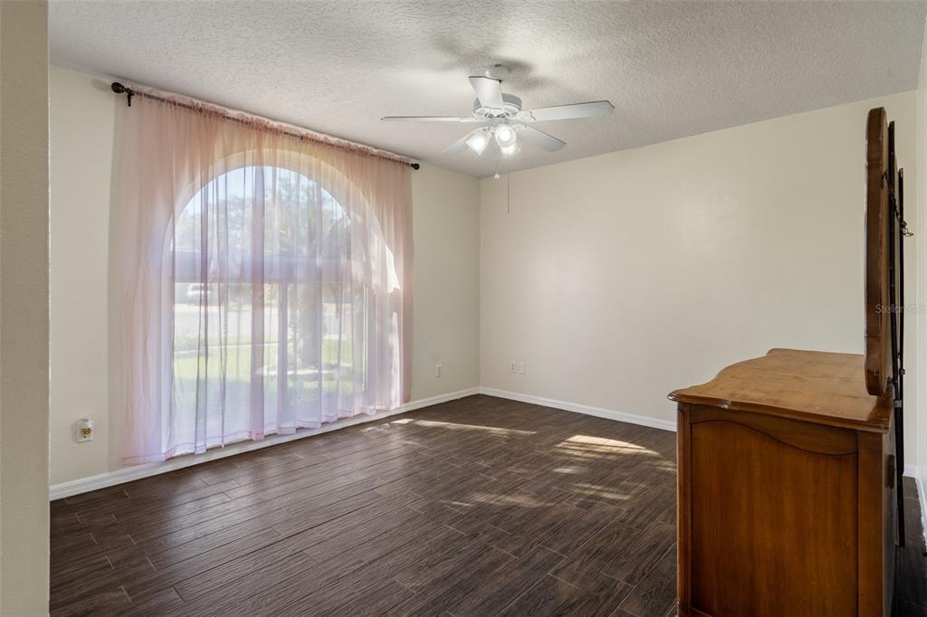 10421 Templewood Court Spring Hill, FL 34608 - Photo 39 of 63 an empty room with wooden floor fan and windows