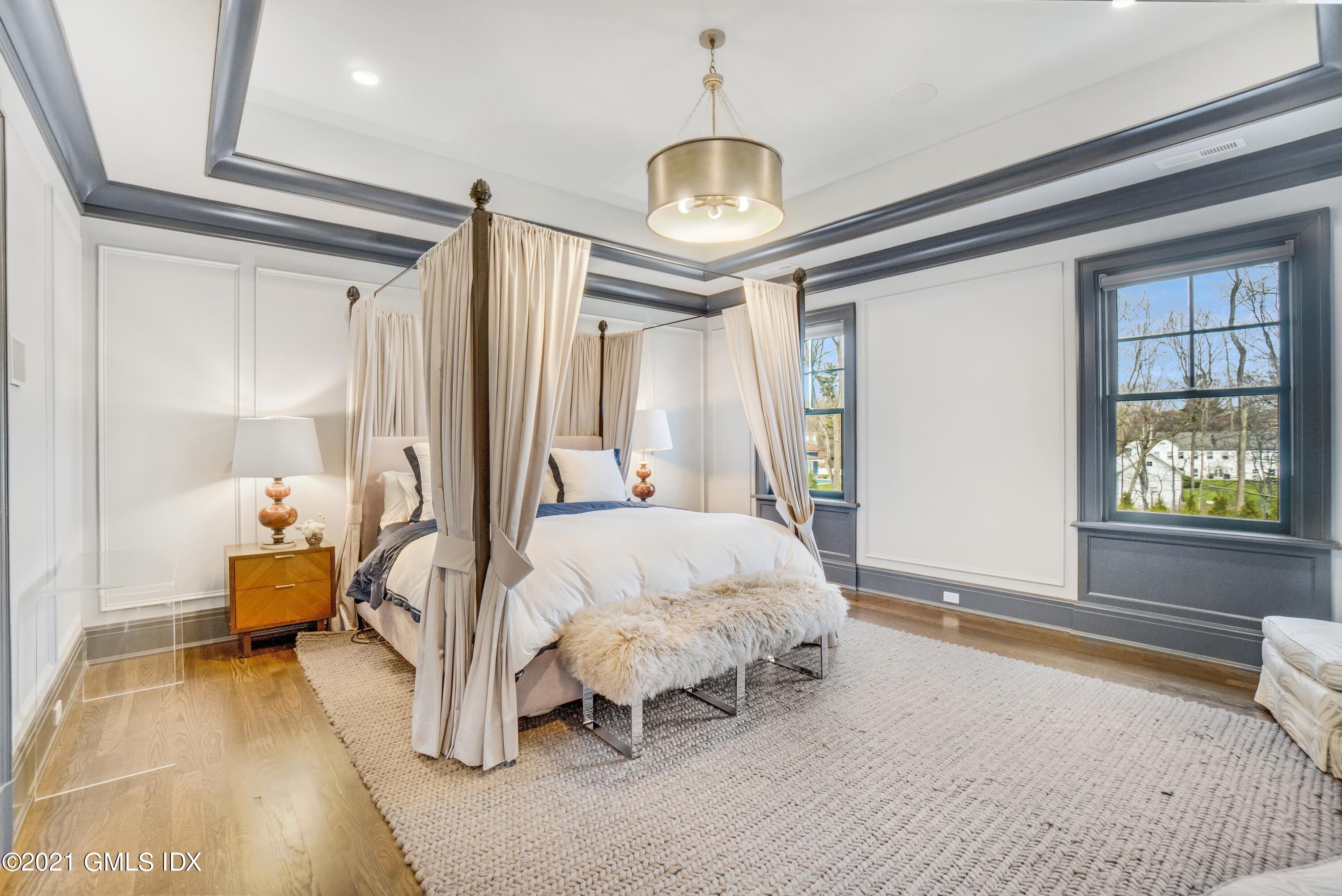 7 Turner Drive Greenwich, CT 06831 - Photo 22 of 34 a spacious bedroom with a bed and a chandelier