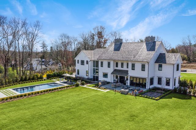 a view of an house with swimming pool garden and trees