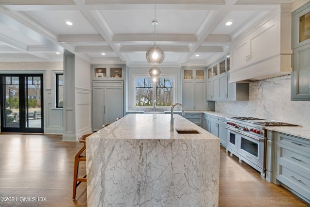 a kitchen with stainless steel appliances granite countertop a sink a stove and a wooden floors