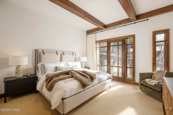 a spacious bedroom with a bed and a couch next to a window