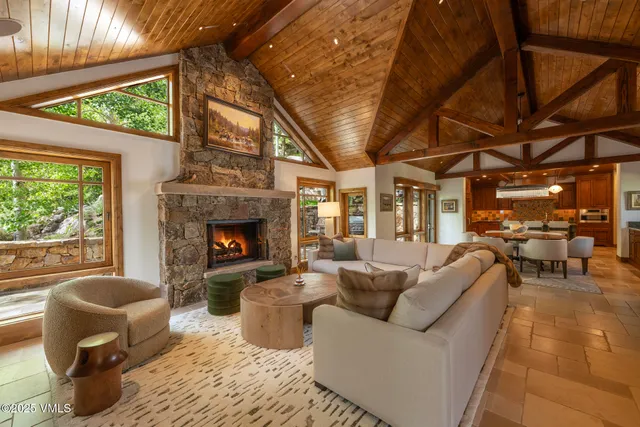 a living room with furniture a fireplace and a large window