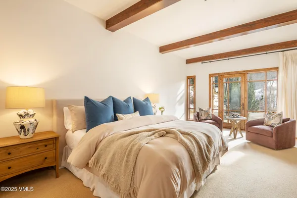 a spacious bedroom with a bed and large windows