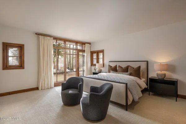 a bedroom with a bed and a couch next to a window