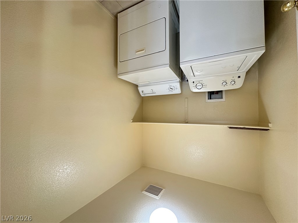 9032 Rutherford Grove Street Las Vegas, NV 89148 - Photo 21 of 24 Conveniently tucked away, this laundry area features stacked appliances and a practical shelf.