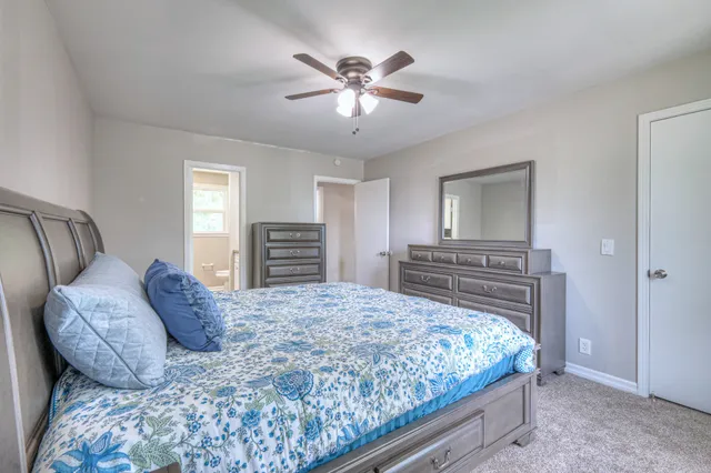 a bedroom with a large bed and a chandelier
