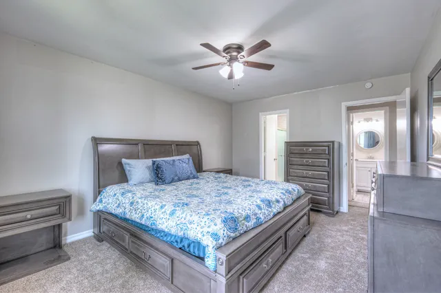a bedroom with a large bed and a chandelier