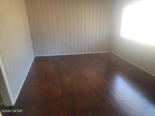 a view of a room with wooden floor and a window