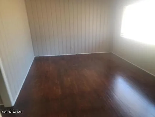 a view of a room with wooden floor and a window