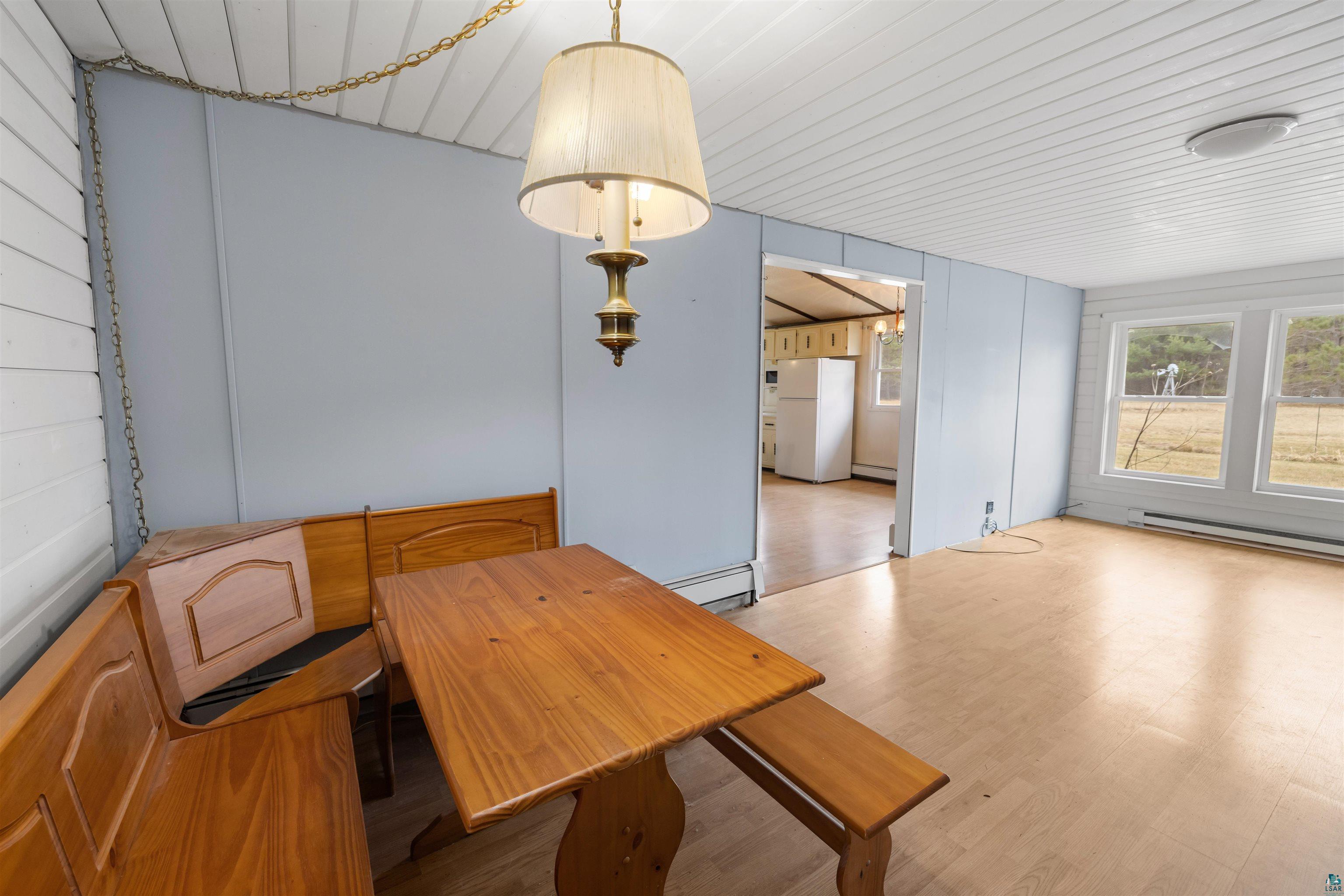11574 Town Line Road Hibbing, MN 55746 - Photo 7 of 41 Spacious room featuring wood-finish flooring, multiple windows, and a built-in corner dining set