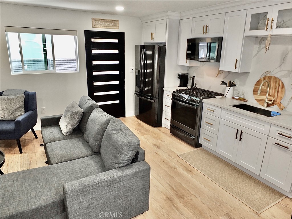 16765 South Pacific Avenue, Unit B' Huntington Beach, CA 90742 - Photo 13 of 45 a living room with furniture a flat screen tv and kitchen view