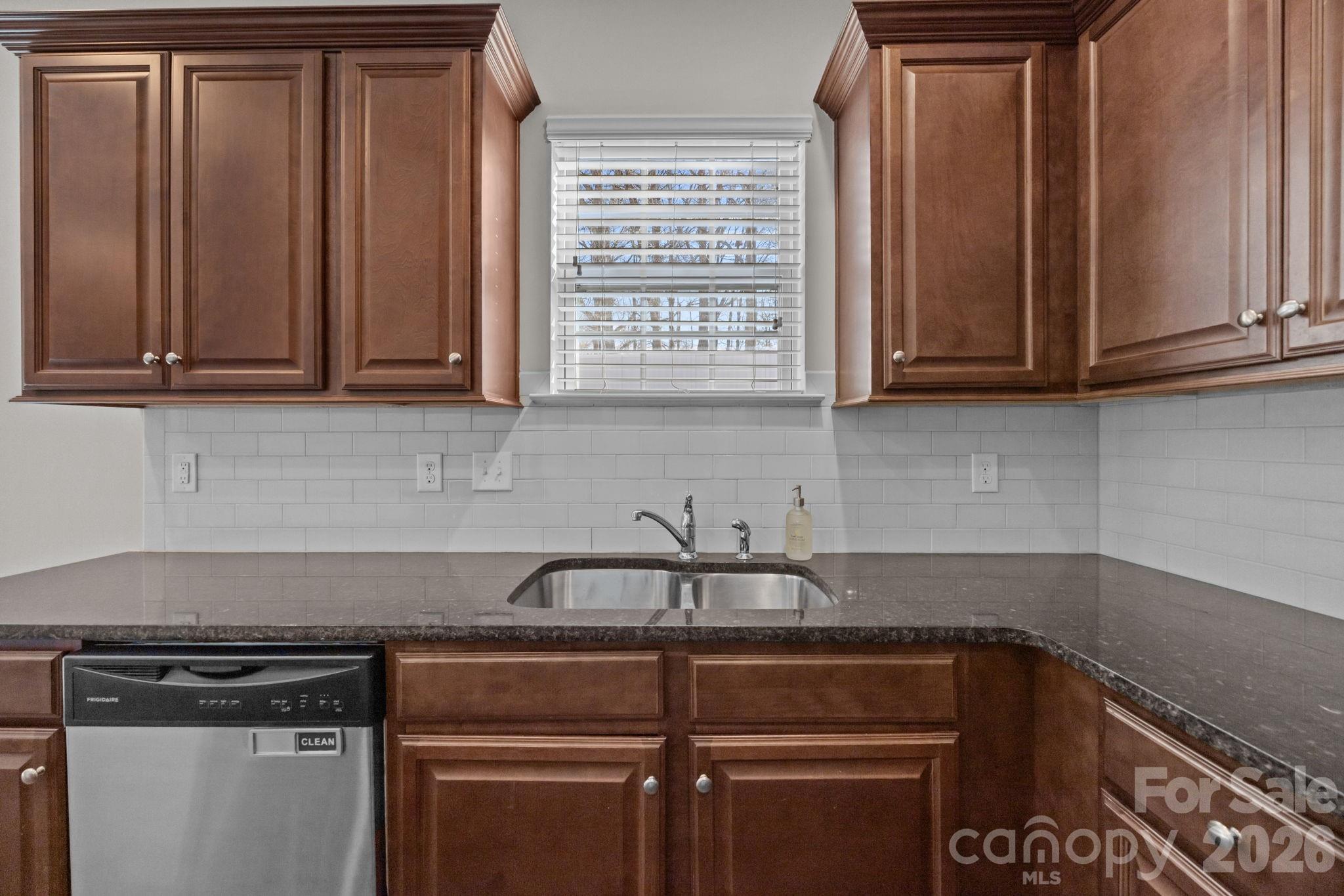 116 Rippling Water Drive Mount Holly, NC 28120 - Photo 17 of 48 a kitchen with granite countertop cabinets and black appliances