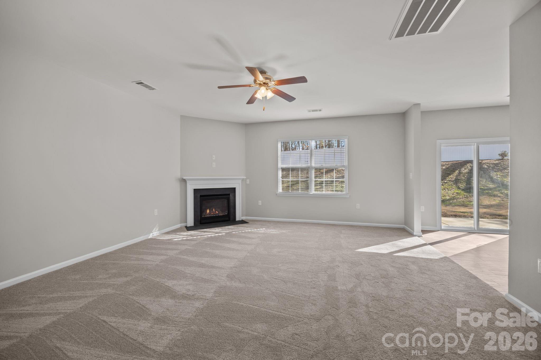 116 Rippling Water Drive Mount Holly, NC 28120 - Photo 7 of 48 an empty room with windows and fireplace