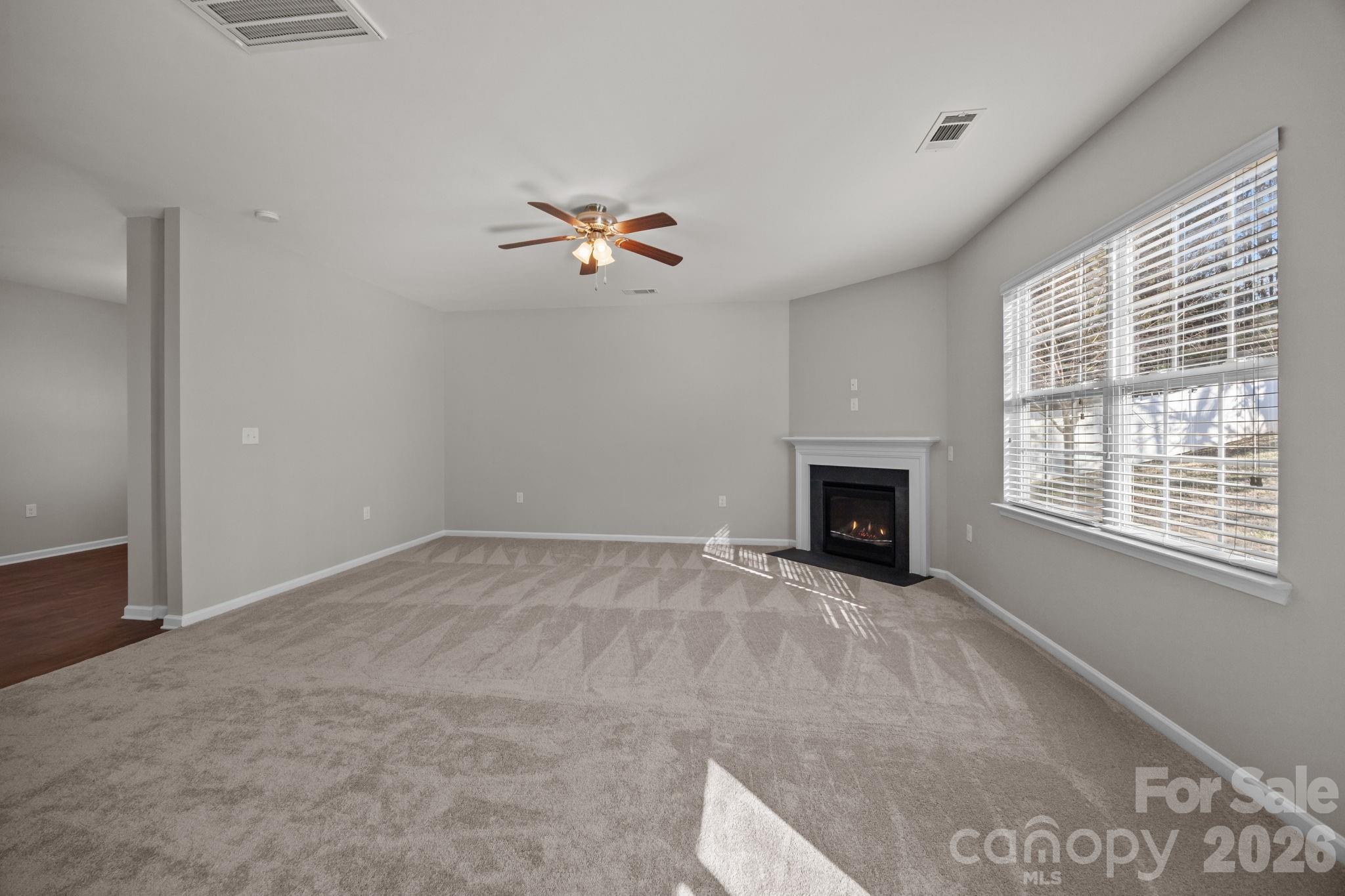 116 Rippling Water Drive Mount Holly, NC 28120 - Photo 9 of 48 a view of empty room with a fireplace and fan