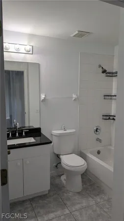 a bathroom with a granite countertop sink a toilet a mirror and shower