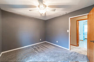 601 Post Street Wanatah, IN 46390 - Photo 16 of 37 an empty room with a chandelier fan and windows