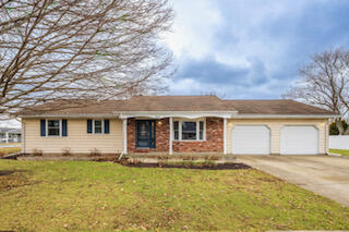 601 Post Street Wanatah, IN 46390 - Photo 2 of 37 a front view of house with yard and trees in the background