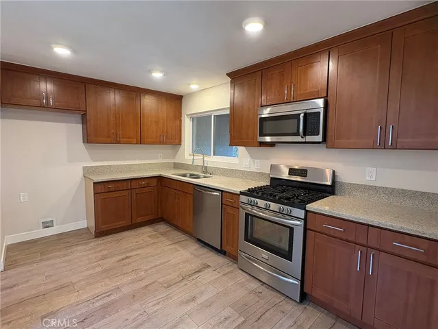 a kitchen with stainless steel appliances kitchen island granite countertop a stove a sink and a microwave