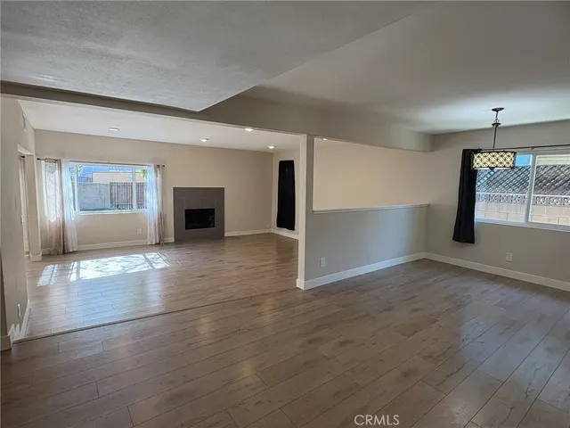 an empty room with wooden floor and a fireplace
