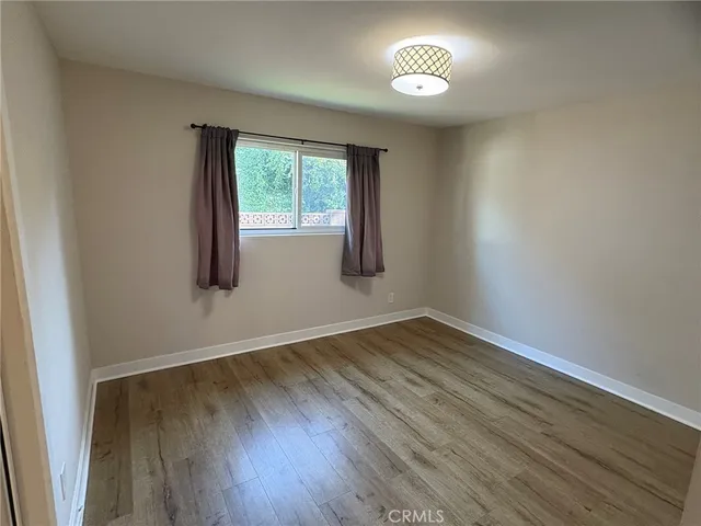 an empty room with wooden floor and a window