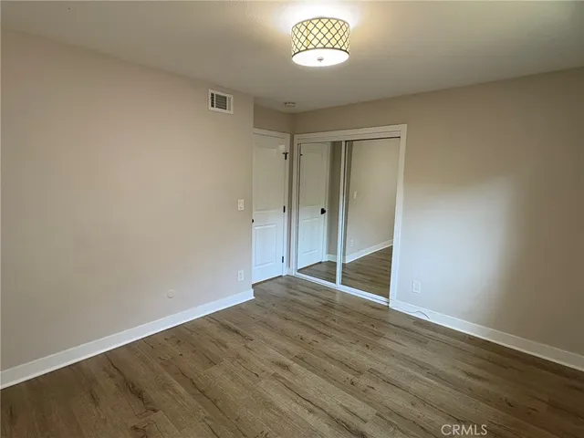 an empty room with wooden floor and window