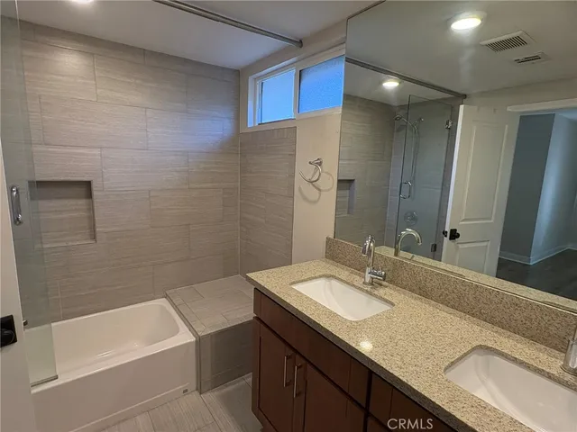 a bathroom with a granite countertop sink mirror toilet and bathtub