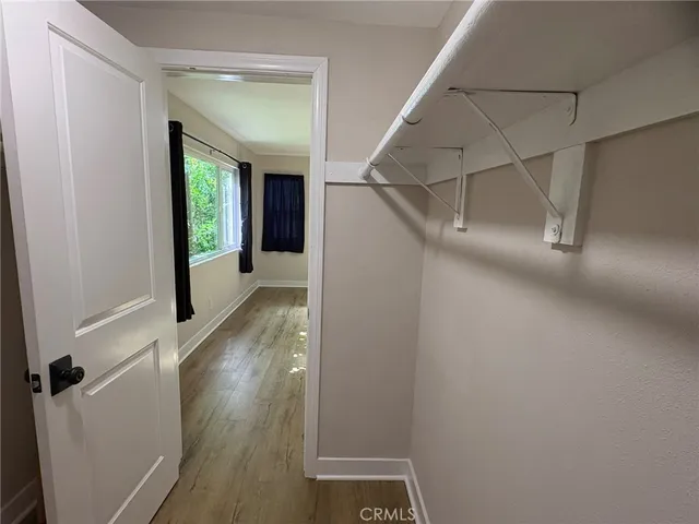 a view of a hallway with wooden floor and entryway