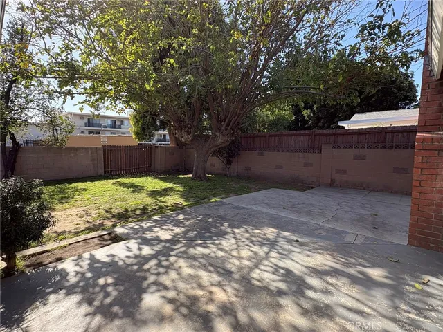 a view of a house with a yard and large tree
