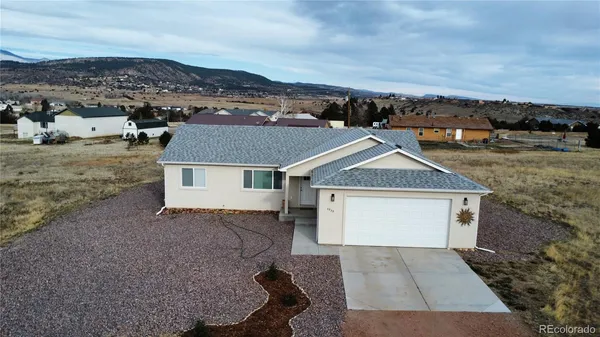 an aerial view of a house with a yard and large tree