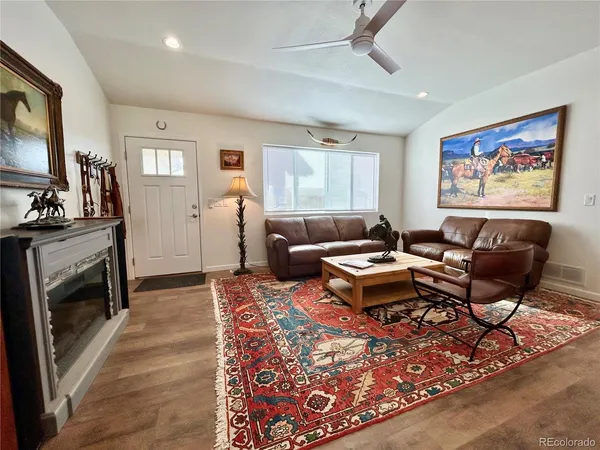 a living room with furniture a flat screen tv and a fireplace
