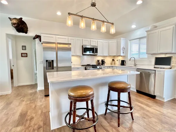 a kitchen with stainless steel appliances granite countertop a sink and a refrigerator
