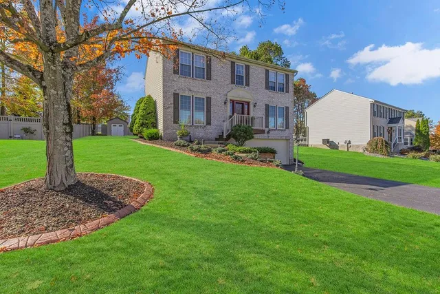 a front view of a house with a garden and yard