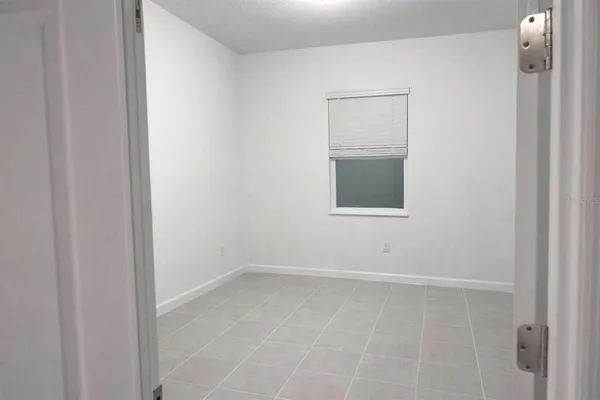 a view of a small space with wooden floor and a window