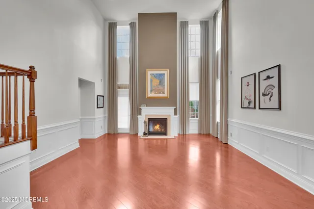 a view of a livingroom with wooden floor and a fireplace