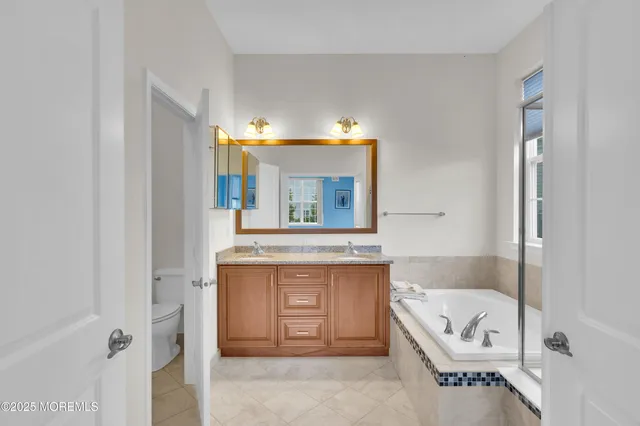 a bathroom with a tub a sink and a mirror