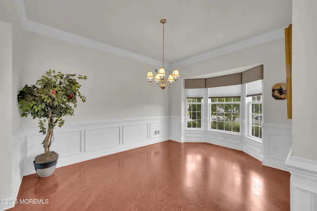 a view of a room with a large window and wooden floor
