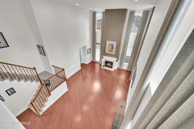 a view of a hallway with wooden floor and stairs