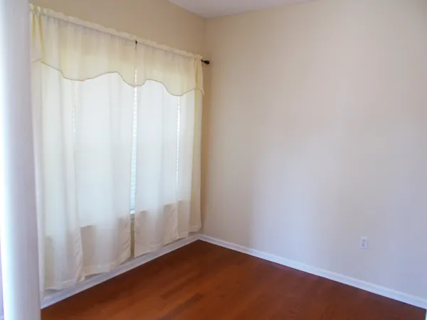 a view of a room with wooden floor and a shower curtain
